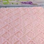 Patterned baby blanket made with knitted and plush (puffy) yarn