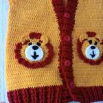 Hand-knitted, lion-themed, yellow and red baby cardigan
