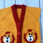 Hand-knitted, lion-themed, yellow and red baby cardigan