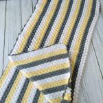 Hand-knitted baby blanket - embossed pattern in yellow, white and anthracite colors.