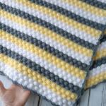 Hand-knitted baby blanket - embossed pattern in yellow, white and anthracite colors.