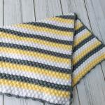 Hand-knitted baby blanket - embossed pattern in yellow, white and anthracite colors.