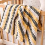 Hand-knitted baby blanket - embossed pattern in yellow, white and anthracite colors.